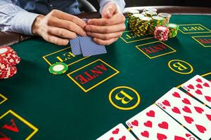 Closeup of poker player with playing cards and chips photo