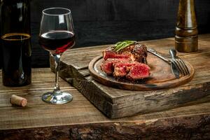 A la parrilla chuletón carne de vaca filete con rojo vino, hierbas y especias en de madera mesa foto