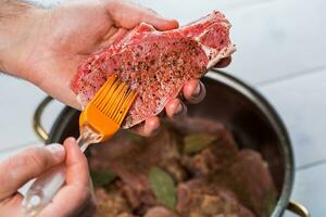 cerca arriba de cocineros manos condimentando el carne foto