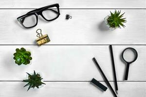 White wooden tabletop with black glasses, two pencils, eraser, magnifier, binder clips and three succulents in pots on it. Close up, copy space photo