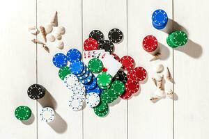 Poker. Set to playing poker with cards and chips on white wooden table, top view photo