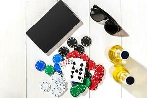 Poker. Set to playing poker with cards and chips on white wooden table, top view photo