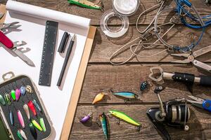 Fishing tackle - fishing spinning, fishing line, hooks and lures on wooden background. photo