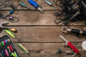 Fishing tackle - fishing spinning, fishing line, hooks and lures on wooden background. photo