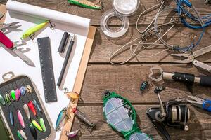 Fishing tackle - fishing spinning, fishing line, hooks and lures on wooden background. photo