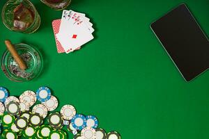 Set to playing poker with cards and chips on green table, top view photo