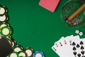 different color chips for gamblings and playing cards on green photo