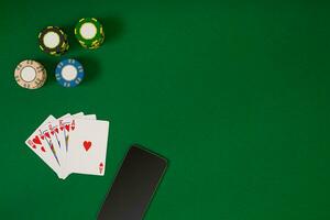 different color chips for gamblings and playing cards on green photo
