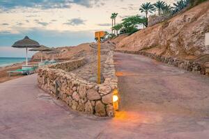 Evening view for a small road on beach in illumination photo