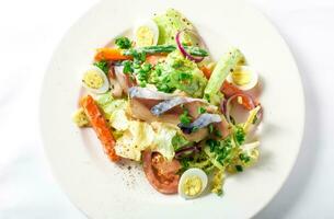 Salad with mackerel fish, zucchini, lettuce, carrots and creamy dressing photo