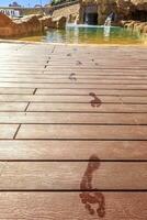 Closeup footprints on the wooden floor behind it swimming pool photo