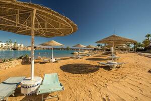 Straw umbrellas and sunbeds on the wonderful tropical beach. photo