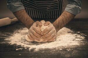 Male hands knead the dough. photo