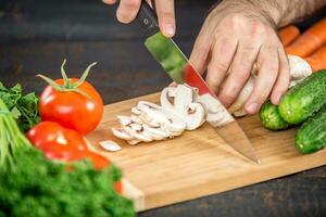 Male hands cutting vegetables for salad photo