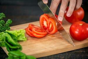 Male hands cutting vegetables for salad photo