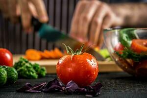 Male hands cutting vegetables for salad photo