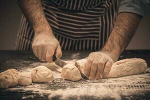 Male hands cut the dough. photo