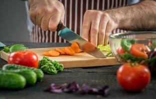 Male hands cutting vegetables for salad photo