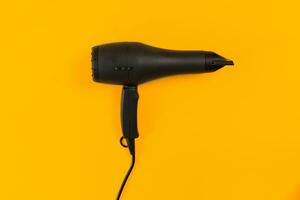 Black Hair dryer on orange background photo