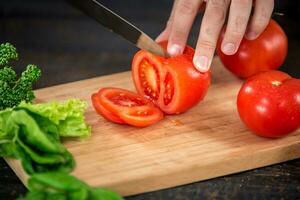 Male hands cutting vegetables for salad photo