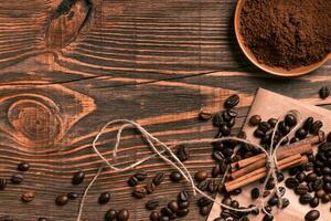 café frijoles, canela palos y suelo café en rústico de madera foto