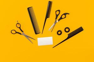 Hairdresser tools on yellow background with copy space, top view, flat lay. photo