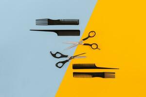 Hairdresser tools on blue and yellow background with copy space, top view, flat lay. photo