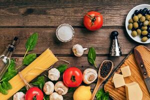 Italian food background with pasta, spices and vegetables. Top view, copy space. photo