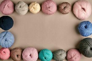 Set of colorful wool yarn on beige background. Top view. Frame of tangles of knitting threads photo