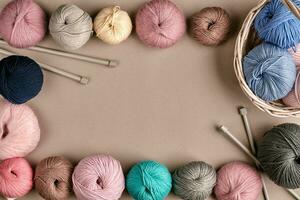 Set of colorful wool yarn on beige background. Top view. Frame of tangles of knitting threads photo