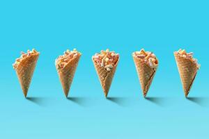 Popcorn in ice cream cones on blue background. photo