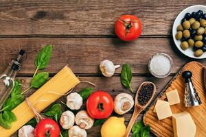 Italian food background with pasta, spices and vegetables. Top view, copy space. photo