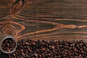 Coffee beans on wooden table texture with copy space. View from photo