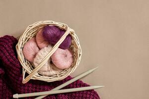Balls of woolen threads and knitting needles. Scandinavian style. Threads for knitting in a basket. photo