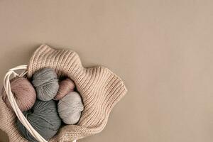 Different colored yarn in basket with knitting needles. Top view photo