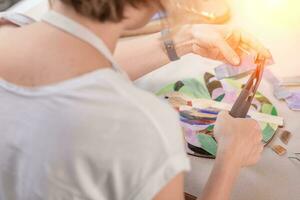 Hands of master working on new modern colorful mosaic. Close-up photo