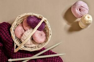 Balls of woolen threads and knitting needles. Scandinavian style. Threads for knitting in a basket. photo