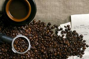 Coffee beans, sheet music and Coffee cup on a burlap background photo