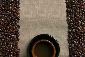 Coffee beans and Coffee cup on a burlap background photo