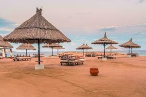 Straw umbrellas and sunbeds on the wonderful tropical beach. photo