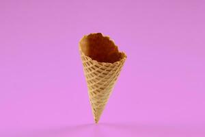 Empty, crispy wafer cone for ice cream against pink background. Concept of food, treats. Mockup, template for your advertising and design. Close up photo