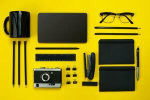 Black objects from the office on a yellow background. Work and creativity. Top view. photo