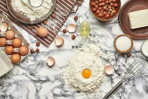 Close-up shot. Top view of a baking ingredients and kitchenware on the marble table background. photo