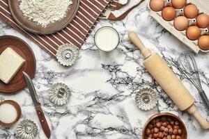 Close-up shot. Top view of a baking ingredients and kitchenware on the marble table background. photo