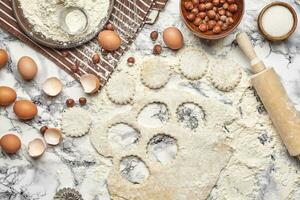 de cerca disparo. parte superior ver de un horneando ingredientes y batería de cocina en el mármol mesa antecedentes. foto