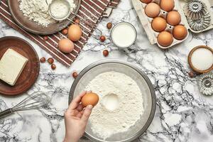 Close-up shot. Top view of a baker cook place, hands are working with a raw dough on the marble table background. photo