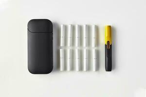 New generation black and yellow electronic cigarette, battery and ten heatsticks isolated on white. New technology. Heating tobacco system. Close up photo