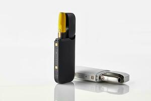 New generation black and yellow, white electronic cigarettes in open batteries isolated on white. Heating tobacco system. Advertising, close up photo