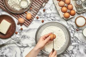 Close-up shot. Top view of a baker cook place, hands are working with a raw dough on the marble table background. photo