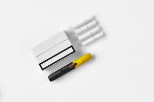 New generation black and yellow electronic cigarette, one pack and four heatsticks, isolated on white. Heating tobacco system. Close up photo